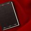 Symbolfoto Urkunden und Stammbuch: Ein dunkles Buch auf rotem Samt