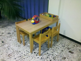 Ein Kindertisch mit vier Stühlen und etwas Spielzeug auf dem Tisch